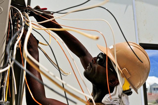 a technician fixes wires in a wall | colorado springs electrician