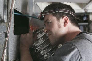 a man searching for duct leaks in colorado springs